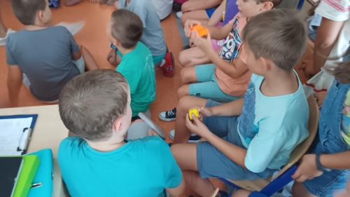 Uczniowie z klasy 3f przeglądają produkty drukowania 3d przyniesione przez prowadzących spotkanie. 